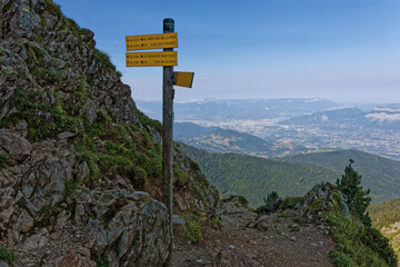 Direction panels near he mountain pass Col de la Sitre, with valley and city of Grenoble in far background.