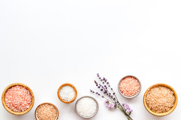 Beauty spa therapy cosmetics and wellness flat lay - sea salt in many bowls with flowers, top view