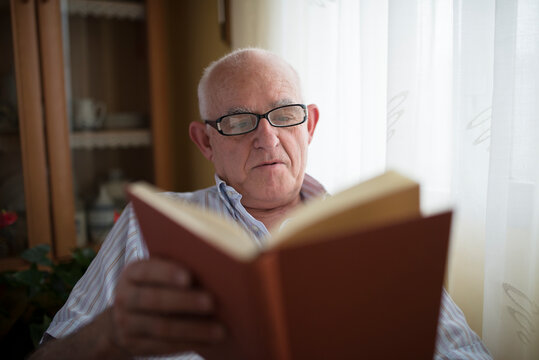 Senior man reading a book at home