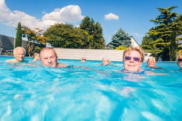 Group of seniors swimimng in swimming pool