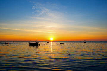 sunset in the sea. Beautiful colorful sky and cloud in twilight time background. Orange fluffy clouds and sun sunlight reflection in the blue sky.