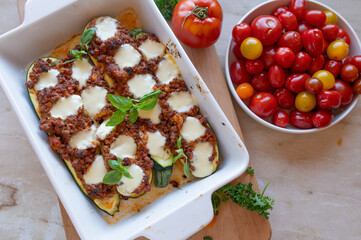 Oven baked stuffed zucchini with minced meat and mozzarella cheese in a casserole dish