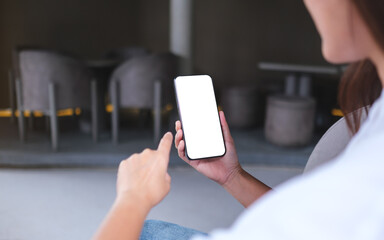 Mockup image of a woman holding and using mobile phone with blank desktop screen in cafe