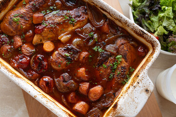Oven braised chicken breast with delicious sauce and vegetables in a casserole dish