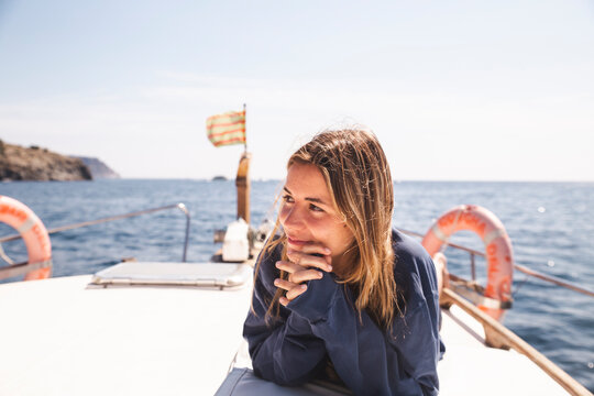 Smiling woman lying on yacht at sunny day