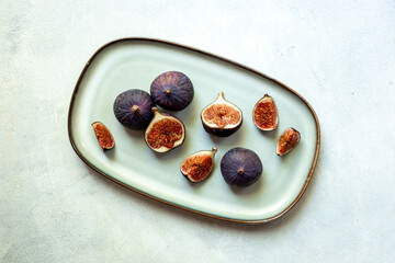 Fresh ripe figs on a plate top view on a gray background