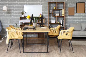 Interior of stylish office with workplace, shelf units and plants