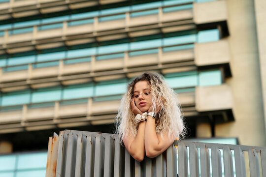 Thoughtful woman with hand on chin leaning on railing