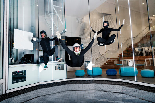 Happy man with friends flying in wind tunnel