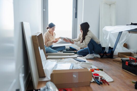 Young lesbian couple installing new furniture at home