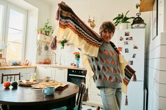 Smiling person in cozy kitchen in the morning enjoying breakfast