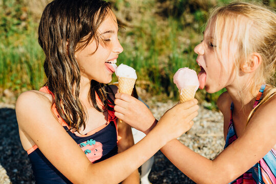 Two girls eating icecream on the beach