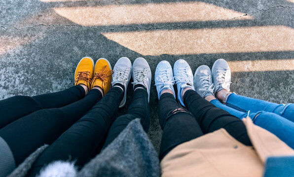 Legs of four friends standing side by side