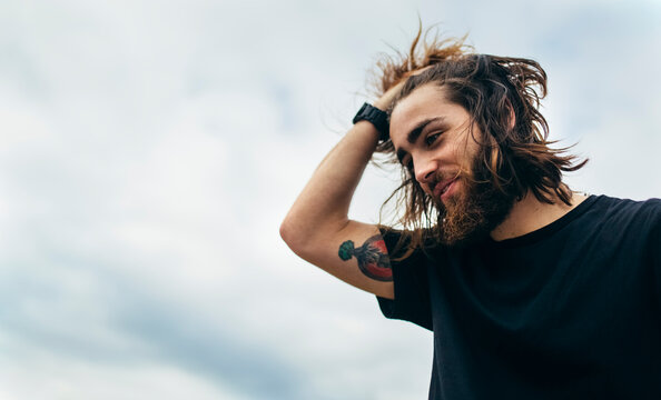 Portrait of bearded young man with tattoo on his upper arm