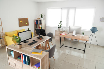Interior of stylish office with modern workplaces and sofa