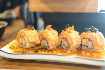 Delicious sushi salmon rolls topped with spicy sauce, high tasty served in plate