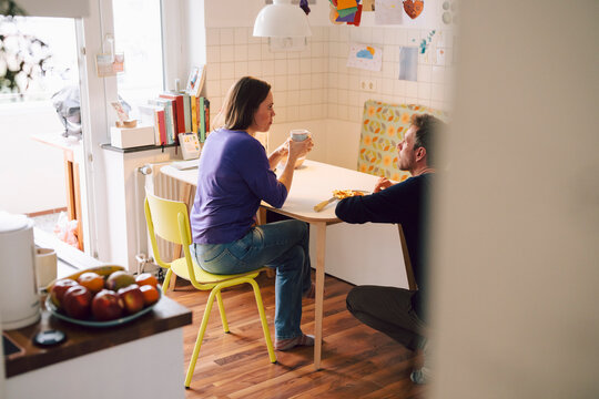 Couple having a conversation in a cozy kitchen setting