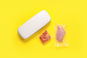 Vacuum sealer machine for food with meat in packs on yellow background