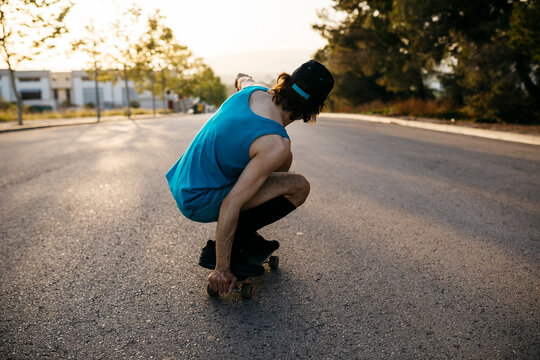 Man skateboarding on empty raos at sunset