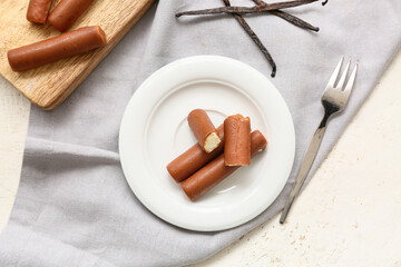 Powdered coffee and tasty curd bars on plate with vanilla on grey background