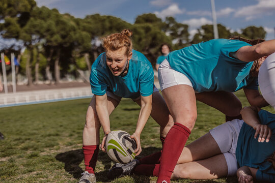 Rugby player holding ball near team on field