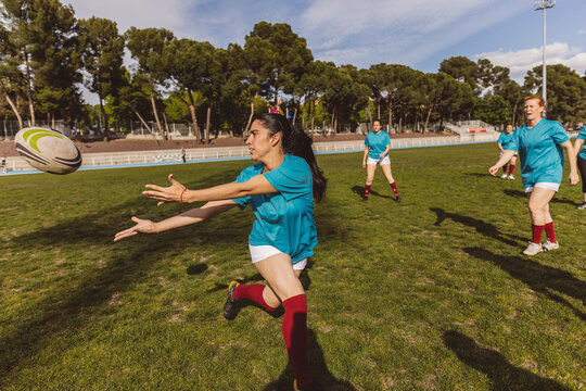 Rugby player catching ball on field