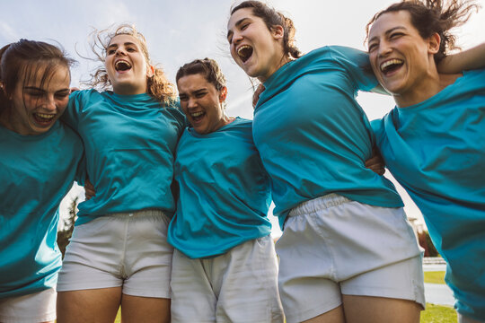 Happy rugby players huddling under sky