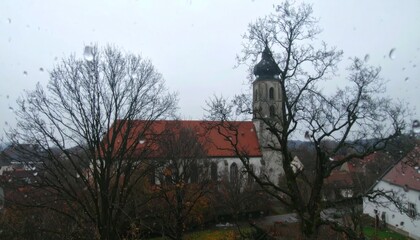 A Serene Church Amidst Bare Trees And Raindrops, Capturing The Tranquil Beauty Of European Architecture On A Cloudy Day, A Visual Masterpiece. With Comprehensive Details And Informative