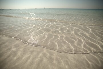 Shallow, clear water washes gently onto a light beige beach