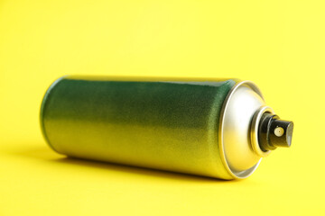 Spray paint can on yellow background