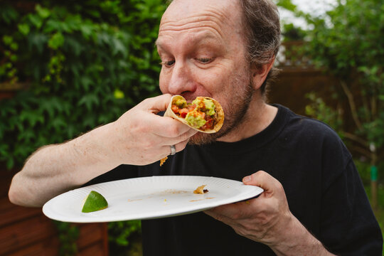 Man enjoying taco outdoors during picnic
