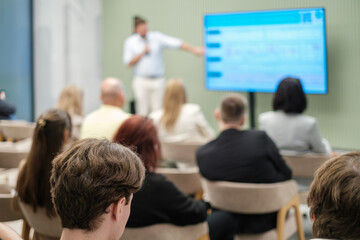 Fototapeta premium Business presentation with attendees focused on speaker and screen in a professional setting