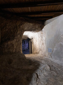 Ancient passage carved into rock in Pretoro, Abruzzo, Italy, leads to glimpse of charming village, showcasing unique architectural heritage