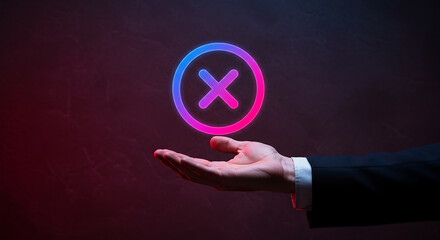 Businessman holding glowing cancel icon, rejection and error concept