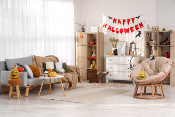 Interior of light living room decorated for Halloween with sofa, armchair and shelf units