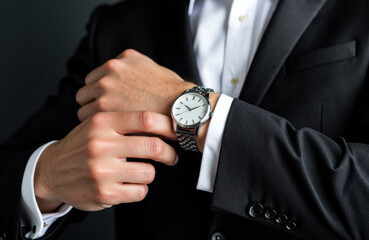 Businessman adjusting wristwatch on formal suit in close-up