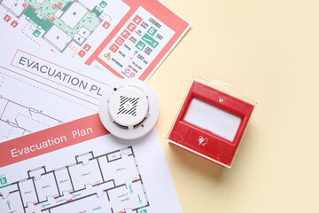Fototapeta na wymiar Modern smoke detector with evacuation plans and fire call point on yellow background