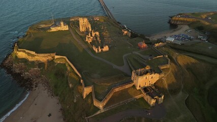 Tynemouth England: 16th August 2025: Tynemouth Priory and Castle overview at sunset with coastal views and ancient ruins. Drone view during golden hour. Slow motion