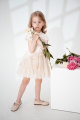 a child with peony flowers on a white isolated background, space for text, a little girl with flowers