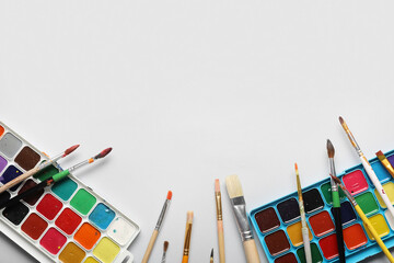 Artist brushes and paints on white background