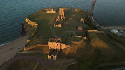 Tynemouth England: 16th August 2025: Tynemouth Priory and Castle overview at sunset with coastal views and ancient ruins. Drone view during golden hour