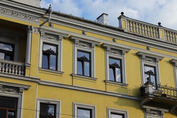 Obraz premium Elegant Yellow Historic Building Facade with Classical Columns and Detailed Window Frames in Cluj-Napoca, Romania