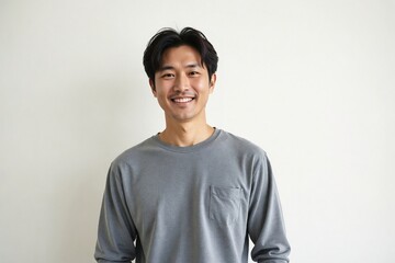 Portrait of a happy and confident 40-year-old Korean man with a genuine smile, standing casually against a clean white background.