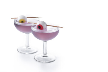 Purple Halloween cocktail garnished with candy eye isolated on white background