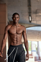 Obraz premium Athletic man under urban overpass showcasing fitness and strength