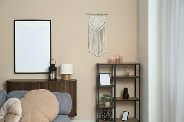 Fototapeta premium Interior of light living room with chest of drawers and shelving unit near beige wall