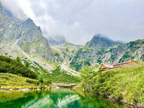  Scenic view of mountain lake and hut (Chata pri zelenom plese) in High Tatras, Slovakia. Zelene Pleso (Green lake) mountain lake in High Tatras, Slovakia