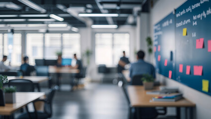 Blurred office interior with people working at desks and a board with sticky notes in a modern workspace