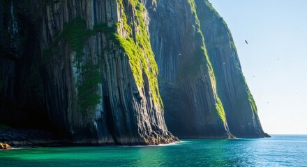 High-angle view of dramatic Karst Limestone Towers rising from turquoise ocean water, showcasing a serene and tranquil mood with vibrant green vegetation clinging to the