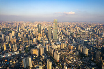 Changsha City, China, presents an expansive aerial panorama of its modern urban landscape with numerous towering buildings under a bright sky.